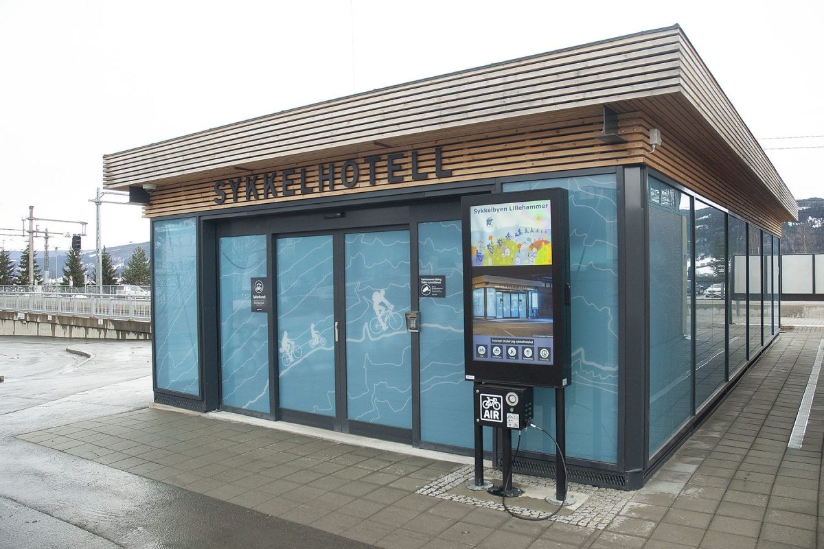 Sykkelhotell for Lillehammer kommune med informasjonsskjerm og glassvegger med dekor