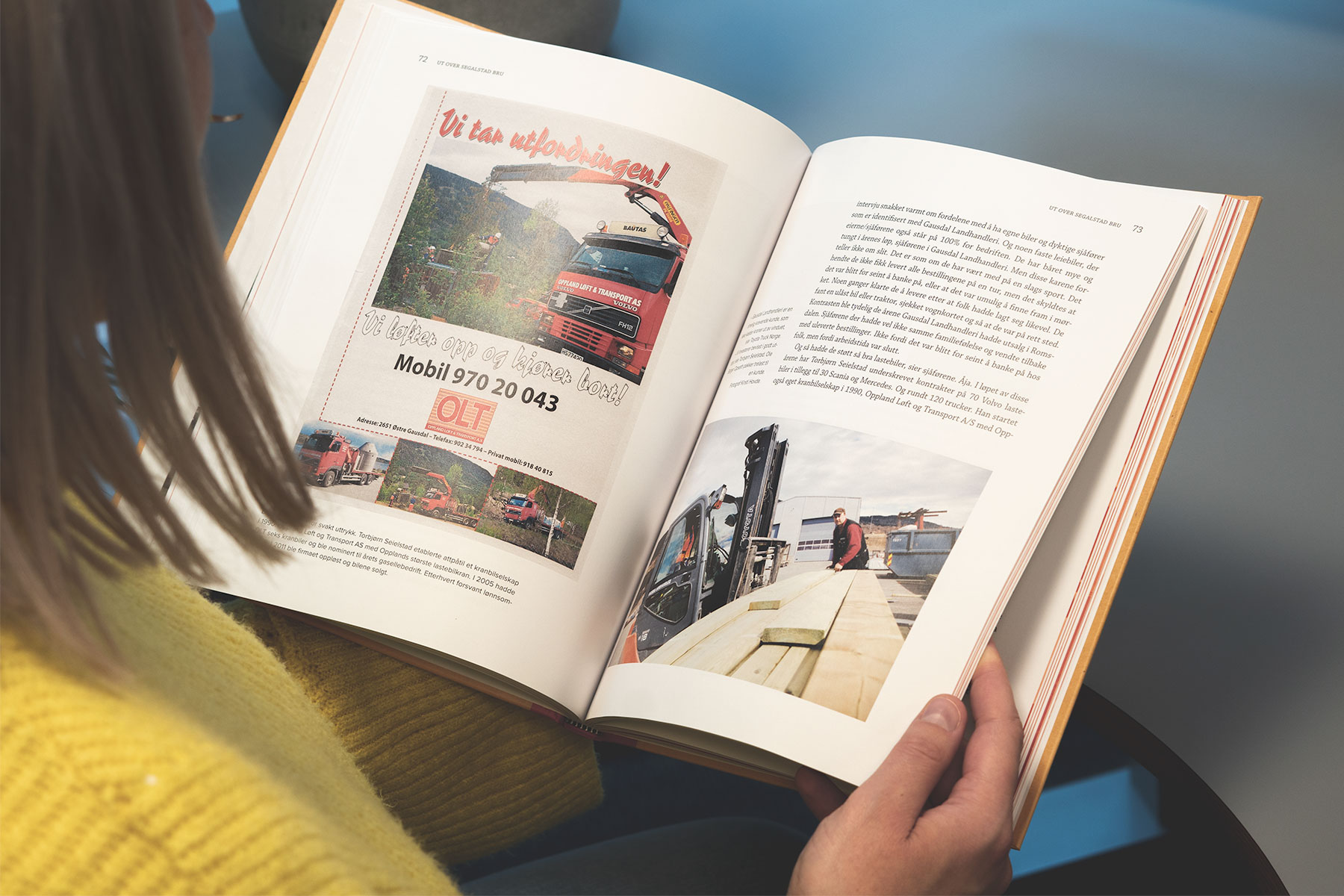 Person leser jubileumsboken for Gausdal Landhandleri