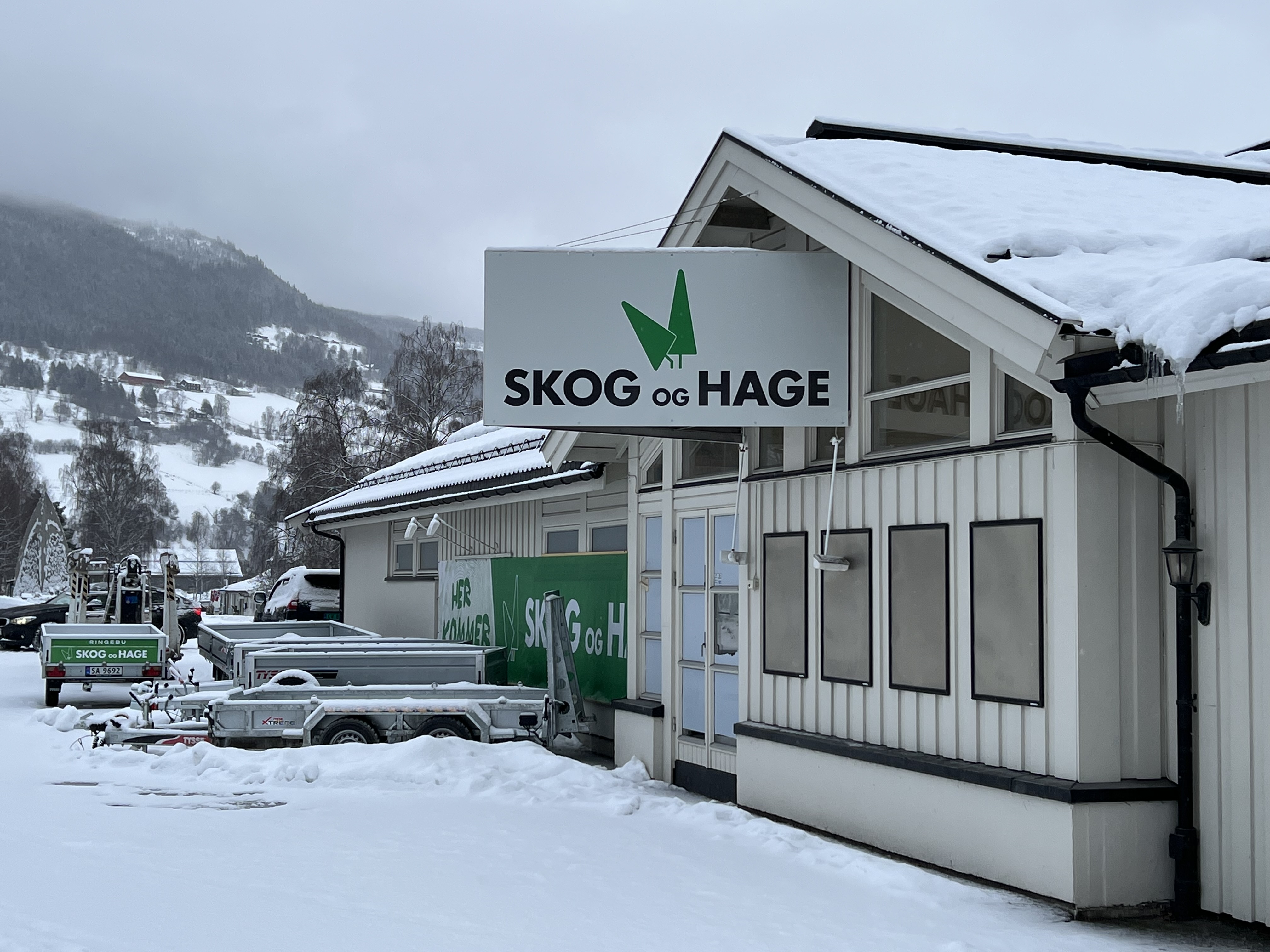 Skilt for Skog og Hage på butikkfasade i snø