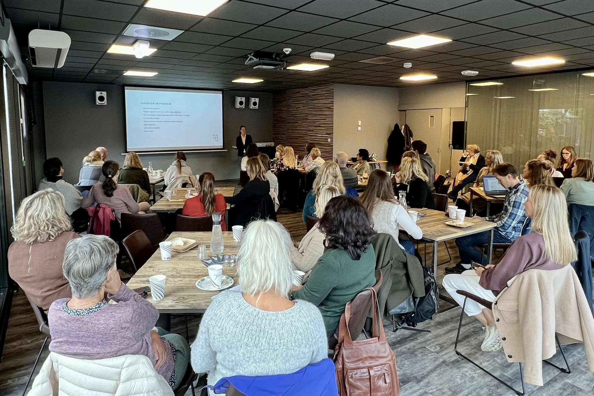 Fullsatt frokostmøte med publikum foran storskjerm