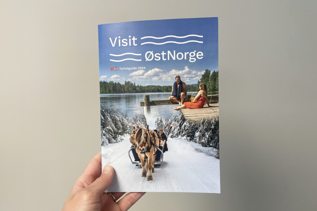 Turistbrosjyre 2024 for Visit Øst-Norge holdt i hånden